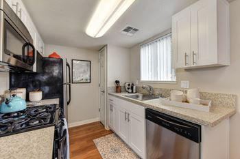 Dining Room/Kitchen with Wood Inspired Floor, Rug, Oven, Stove with Blue Tea Kettle, Microwave1 at Addison Ranch Apartments, California, 94954